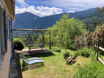 a patio with a picnic table and a bench at Gîte chez Arthur in Vezzani