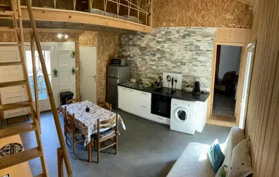 a kitchen with a table and a stove top oven at Gîte chez Arthur in Vezzani