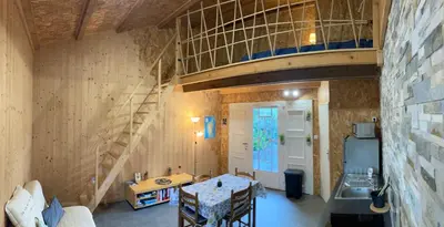 a room with a staircase and a room with a table at Gîte chez Arthur in Vezzani