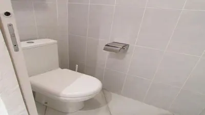 a bathroom with a toilet and a toilet paper dispenser at MiniVilla 