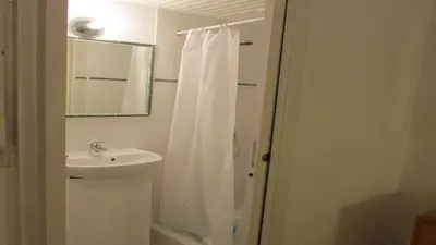 a bathroom with a sink and a white shower curtain at MiniVilla 