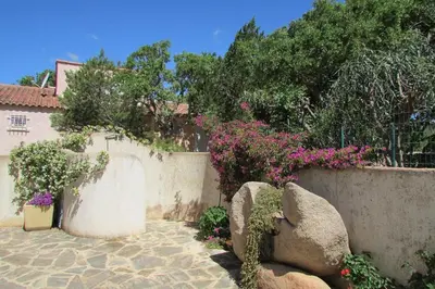 a garden with flowers and a stone wall at MiniVilla 