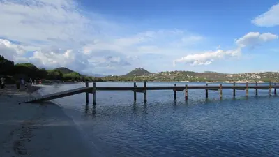 a dock in the water next to a beach at MiniVilla 