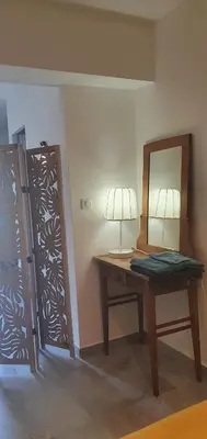 a room with a table with a lamp and a mirror at Vue de rêve in Calcatoggio