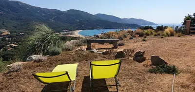 two yellow chairs sitting on top of a hill at Vue de rêve in Calcatoggio