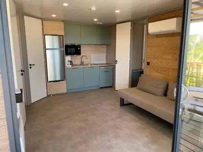 a living room with a couch and a kitchen at La vallée in Belvédère
