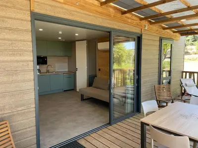 a screened in porch with a table and a kitchen at La vallée in Belvédère
