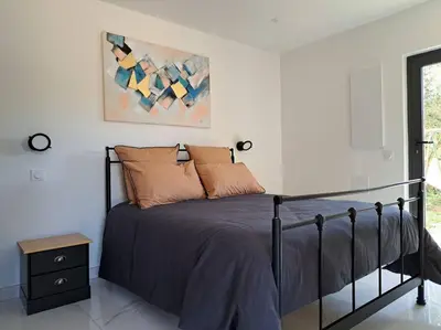 a bedroom with a bed and a painting on the wall at Maison au calme idéalement située proche plage in Bonifacio