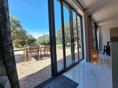 a room with a sliding glass door looking out at a patio at Maison au calme idéalement située proche plage in Bonifacio