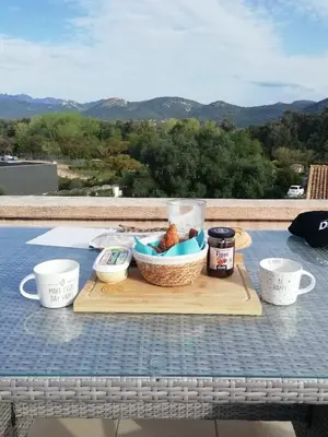 a picnic table with a basket of food and cups at Altura in Zonza
