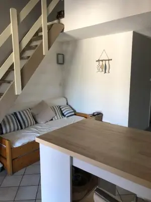 a living room with a couch and a staircase at Altura in Zonza
